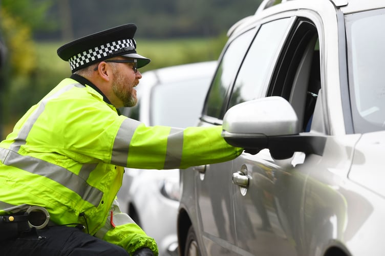 Police officer talking to driver of stopped car