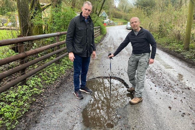 David Davies MP and Cwmyoy resident Rob Abell inspect the potholes on Cwm Road.