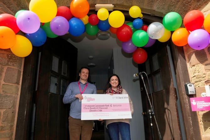 Cllr Lowri Morgan accepts the cheque from the lottery's Michael Dupree