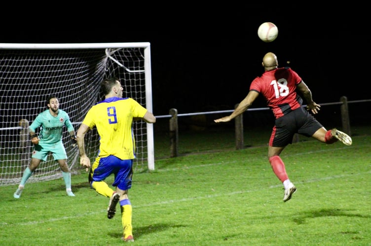 A Goytre player leaps for the ball in the box