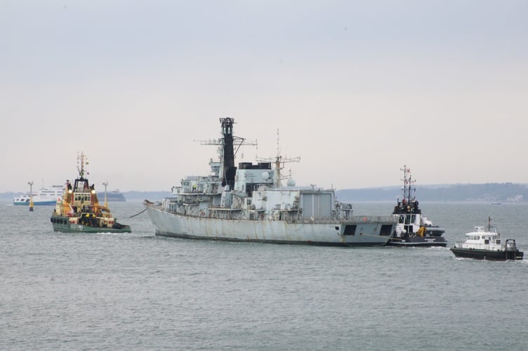 HMS Monmouth being towed to sea on its final voyage today