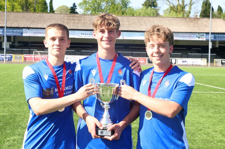 Monmouth's three goalscorers Herbie Perry, Lucas Harris and George Gouldingay get their hands on the cup