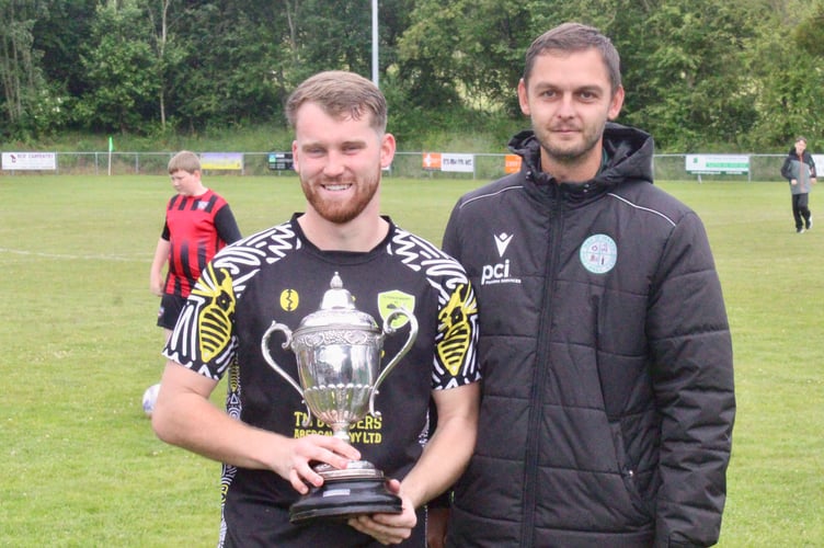 Ben Sherman is presented with the Hay Challenge Cup by Dan Jones of the host club 