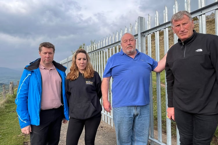 Cllr Richard John, far left, with Cllr Fay Bromfield, local farmer Wayne Elliot and Cllr Simon Howarth standing beside the steel fence dubbed the \'Great Wall of Clydach\'.
