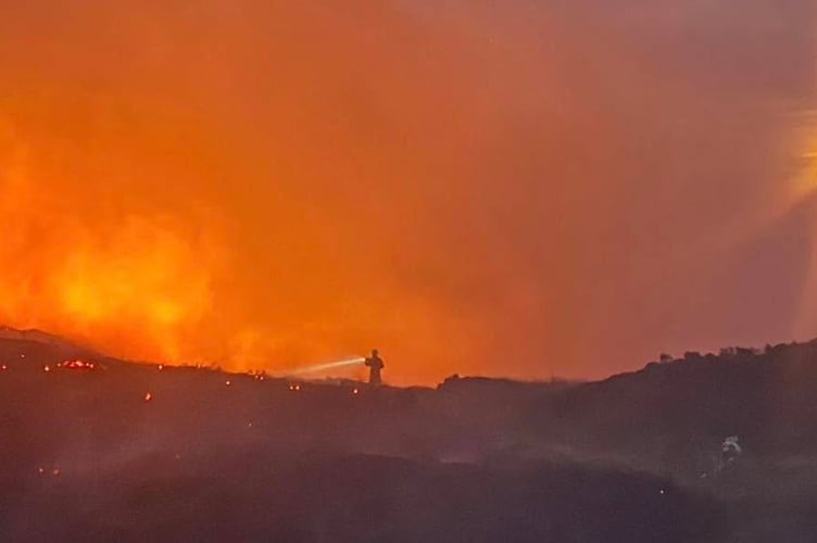 A firefighter fights the wildfire blaze near Clydach Dingle
