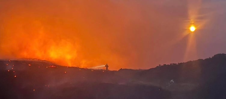 A firefighter fights the wildfire blaze near Clydach Dingle