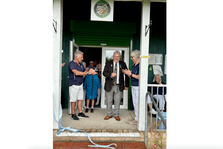 Peter Williams, the President of Monmouthshire Bowling Association, cuts the ribbon at the Gilwern clubhouse.