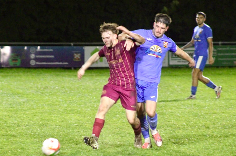 A Bluebirds plater (in red) just gets his foot to the ball ahead of an Abergavenny player