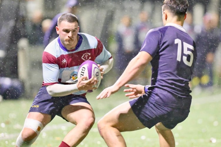 Crawshays player Lewis Bates takes on the Oxford full-back as the rain falls
