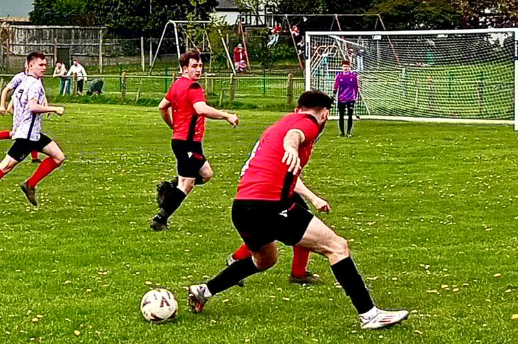 It's behind you! The ball goes loose as Mardy Development's Leighton Melia tries to get them on the front foot 
