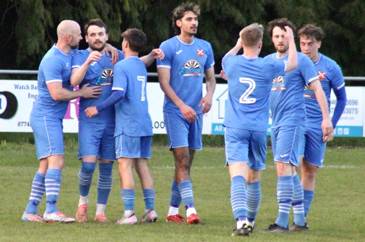 The Pennies celebrate after Ben Brooks, second from left, broke the deadlock 