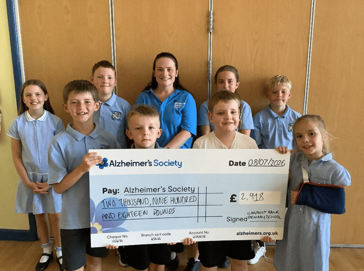 Children from Llanfoist Primary presenting their cheque to charity