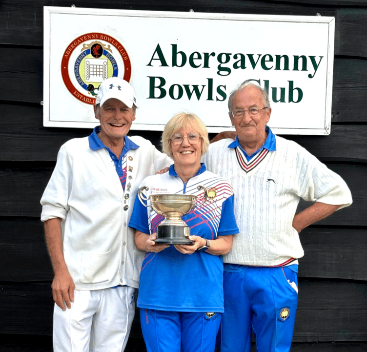 Mary Evans holds the triples trophy beside Ian McCuish and Rob Poynter