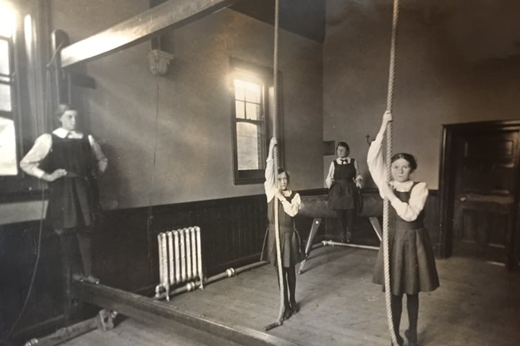 Some girls climbing ropes in an old school